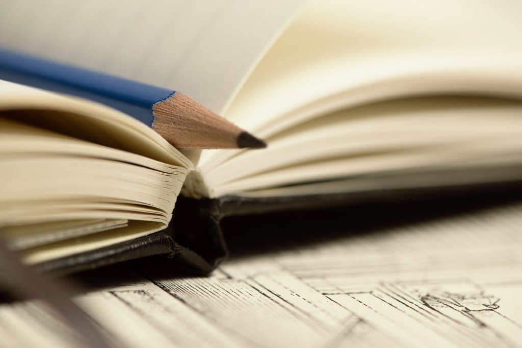 A notebook and a blue pencil